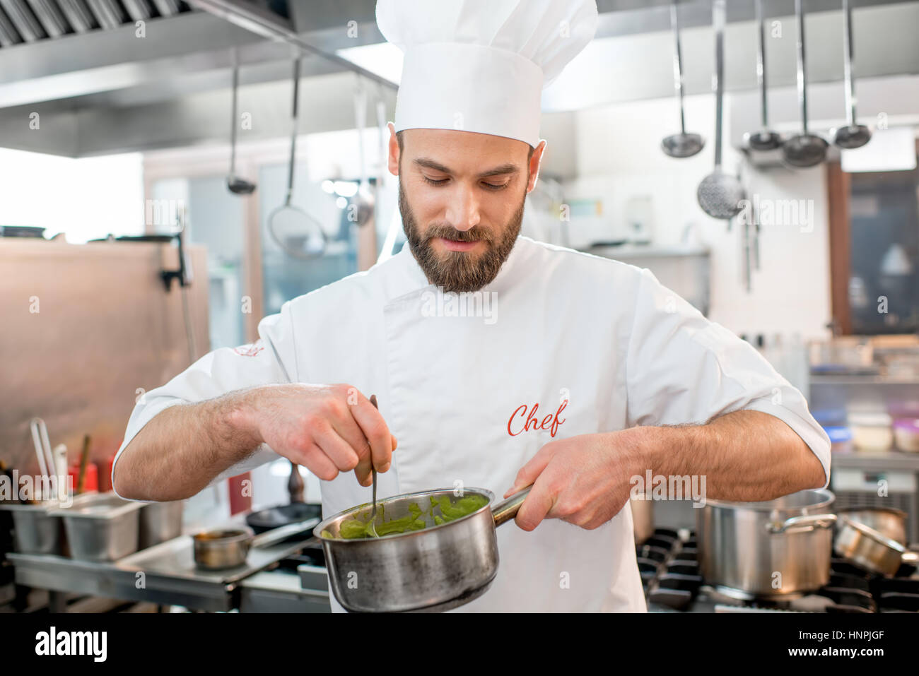 Bello chef di cucina rendendo sause presso il ristorante cucina Foto Stock