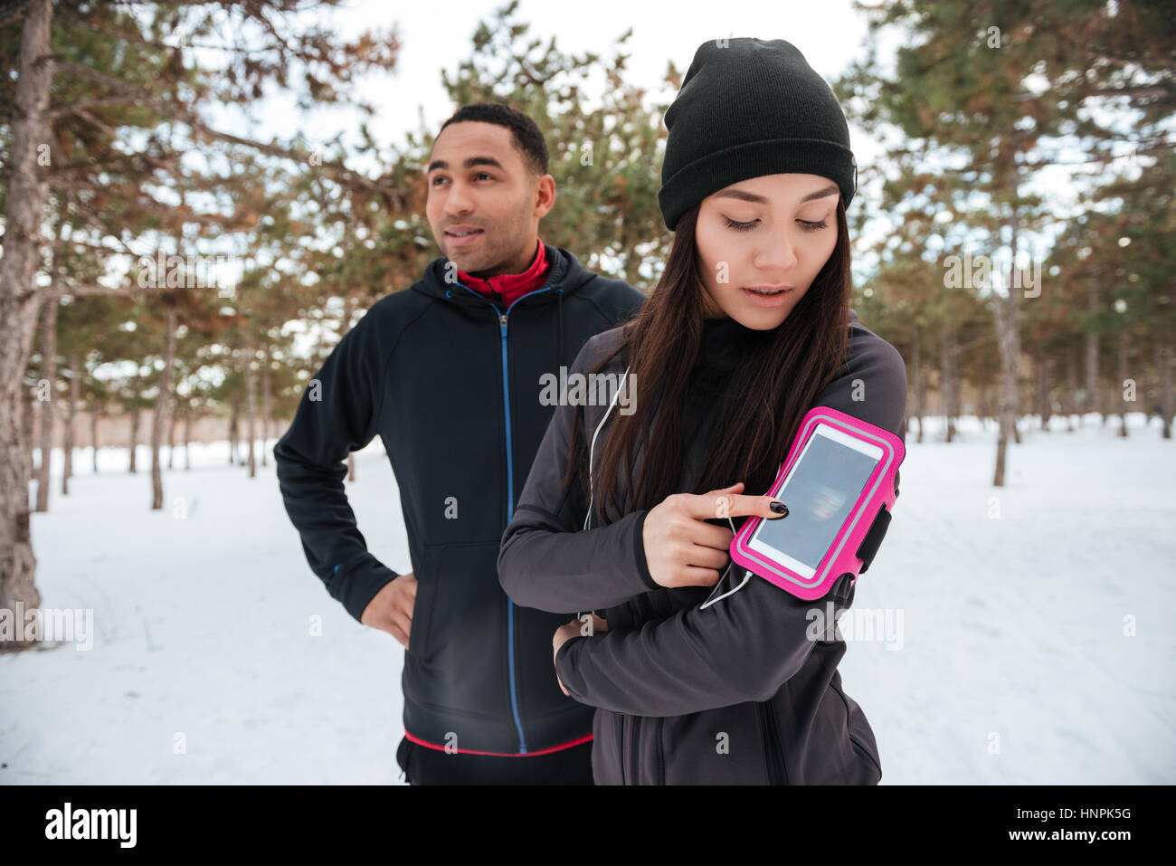 Giovani multirazziale sport giovane ottenere pronto per l'esecuzione di maratona in foresta invernale Foto Stock