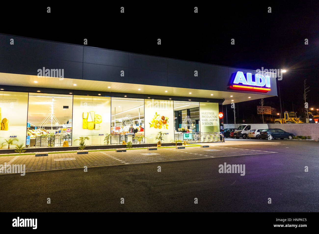 Un supermercato Aldi illuminata di notte a Malaga, Spagna. Foto Stock