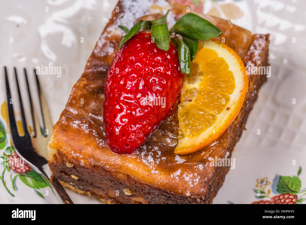 Pezzo di torta di frutta con fragola e limone sul piattino con forcella sul tavolo di legno Foto Stock