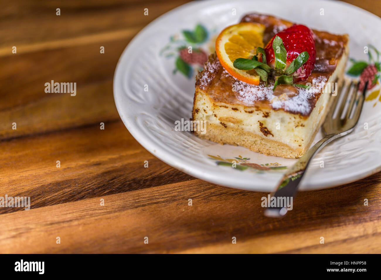 Limone la torta di fragole con fragola e limone sul piattino con forcella sul tavolo di legno Foto Stock