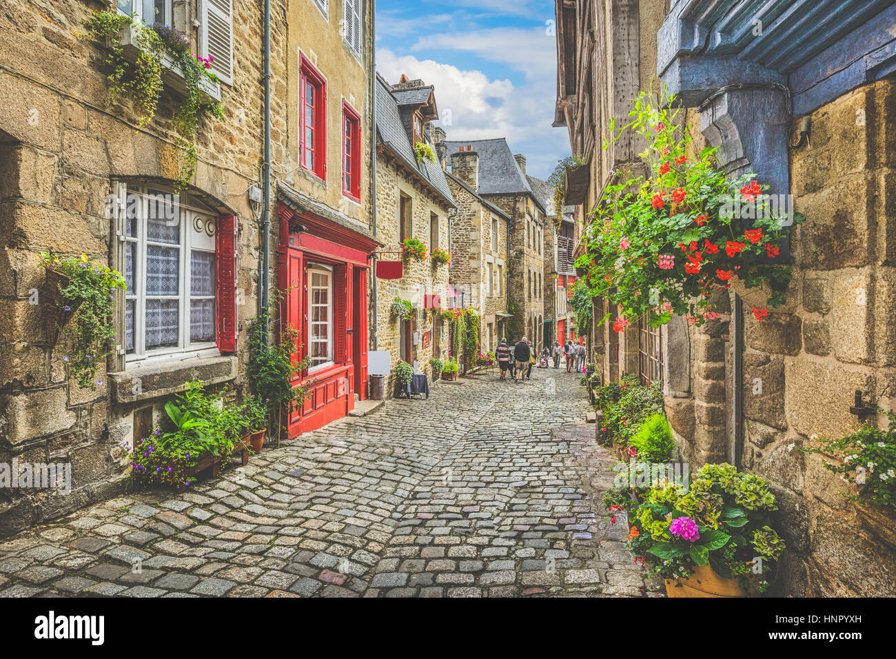 Bellissima vista panoramica stretto vicolo storico con case tradizionali e strada di ciottoli in una vecchia città in Europa con il cielo blu e nuvole in estate Foto Stock