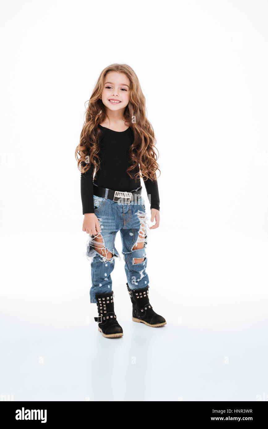 Lunghezza completa di allegro bambina in jeans strappati in piedi e  sorridente su sfondo bianco Foto stock - Alamy