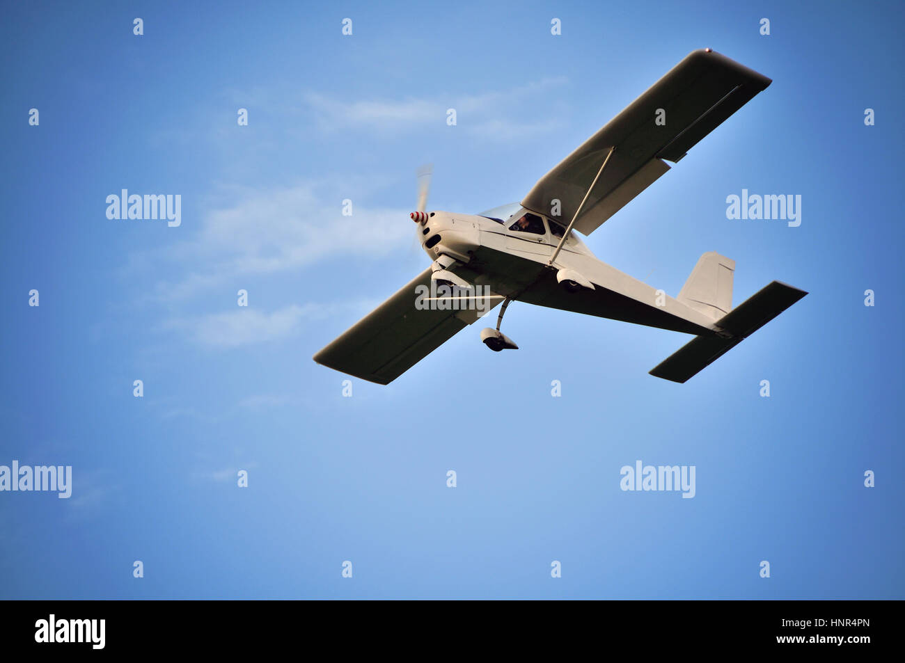 Piccolo aereo nell'aria. Il cielo blu con nuvole bianche. Foto Stock