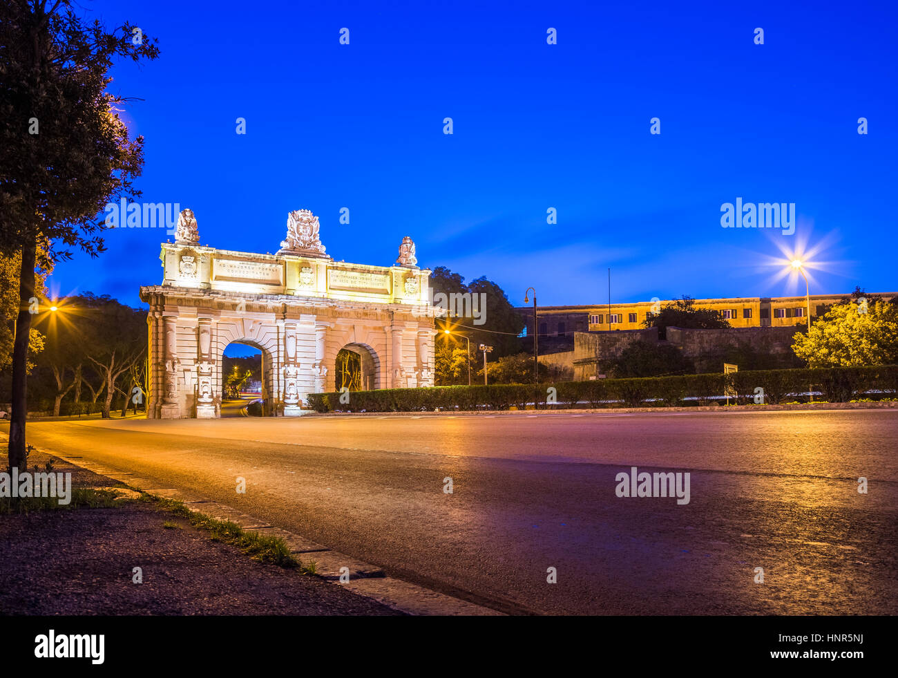 Floriana, Malta - nelle prime ore del mattino presso la Porte des Bombes o Floriana porta a La Valletta con vuoto street e cielo blu chiaro Foto Stock