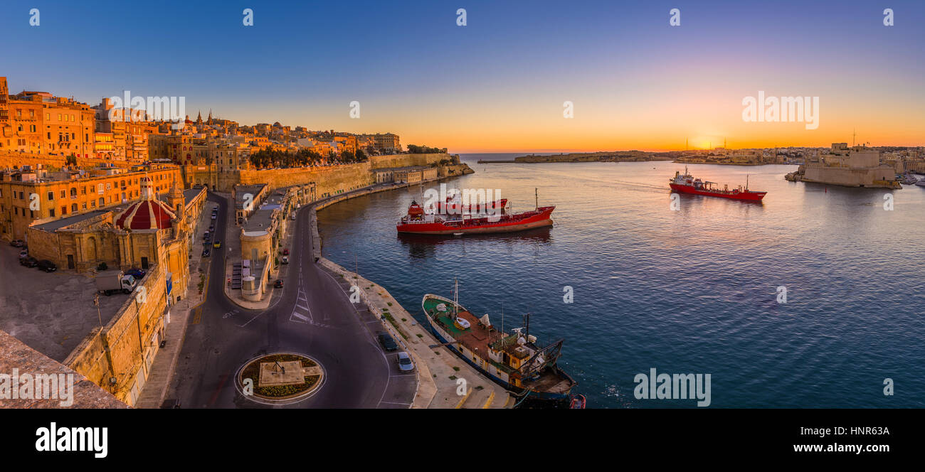 La Valletta, Malta - scatto panoramico di una fantastica estate sunrise a La Valletta Grand Harbour con le navi e le antiche case e le pareti dei maltesi ca Foto Stock