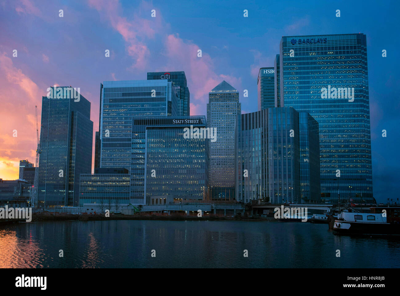 Il sole tramonta dietro al Canary Wharf, Londra. Foto Stock