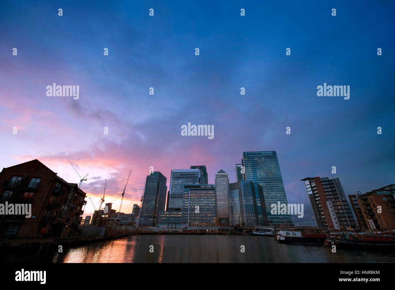 Il sole tramonta dietro al Canary Wharf, Londra. Foto Stock