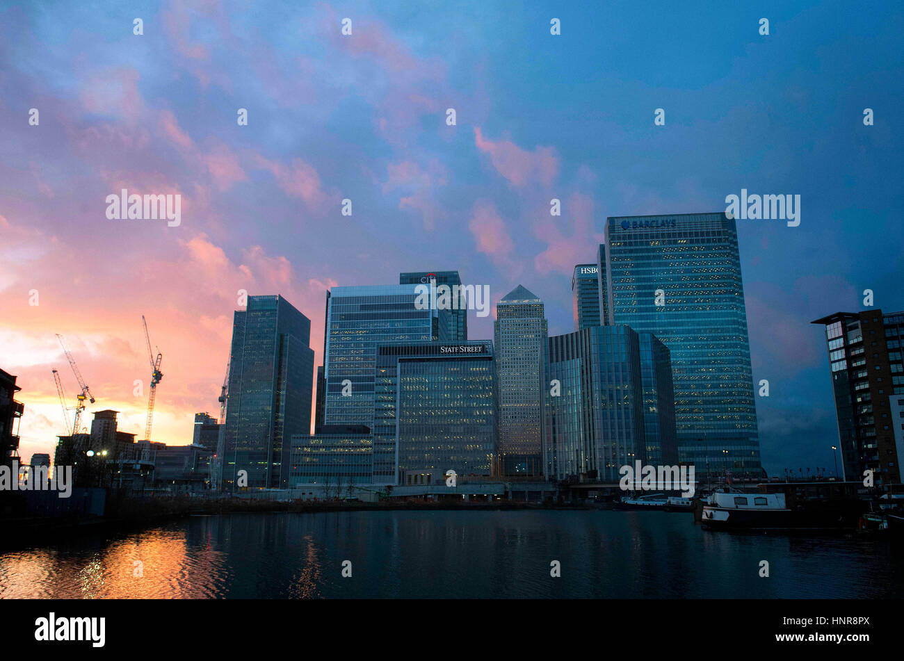 Il sole tramonta dietro al Canary Wharf, Londra. Foto Stock