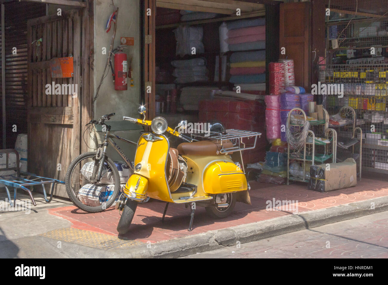 Giallo scooter parcheggiato sul marciapiede in Chinatown, Bangkok, Thailandia Foto Stock