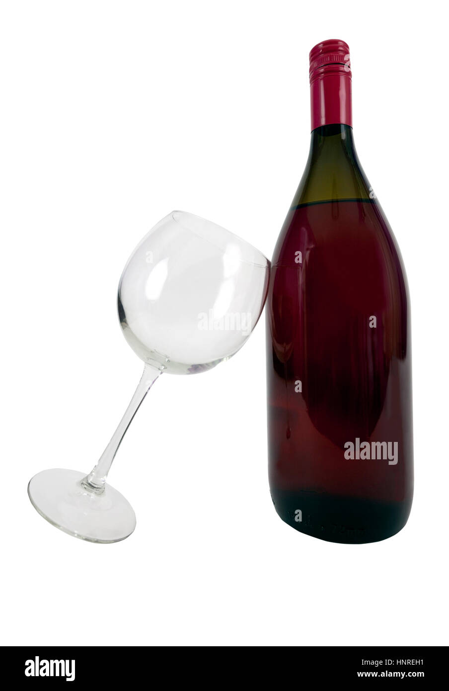 Vino rosso bottiglia vuota con bicchiere di vino appoggiata contro la bottiglia. Isolato. Verticale. Foto Stock