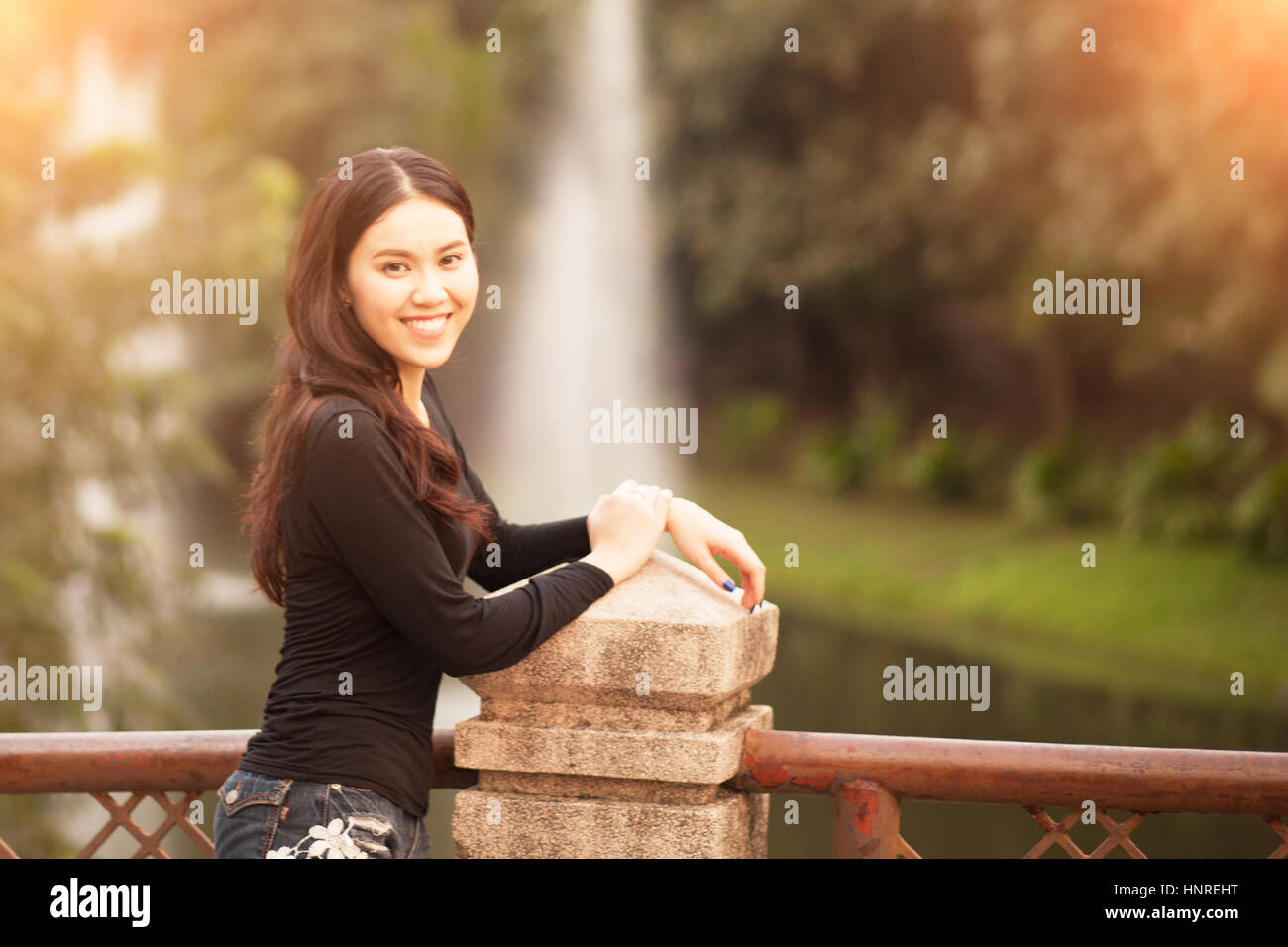 Pretty thai ragazza sorridente al parco Foto Stock