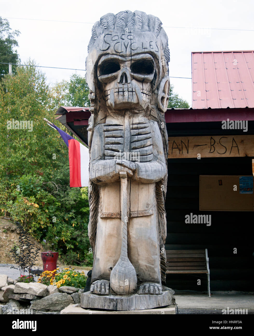 Un'imponente scultura di Death Tiki Head accoglie i visitatori in un negozio di motociclette nella Maggie Valley, North Carolina, che mescola arte stradale con la cultura dei motociclisti. Foto Stock