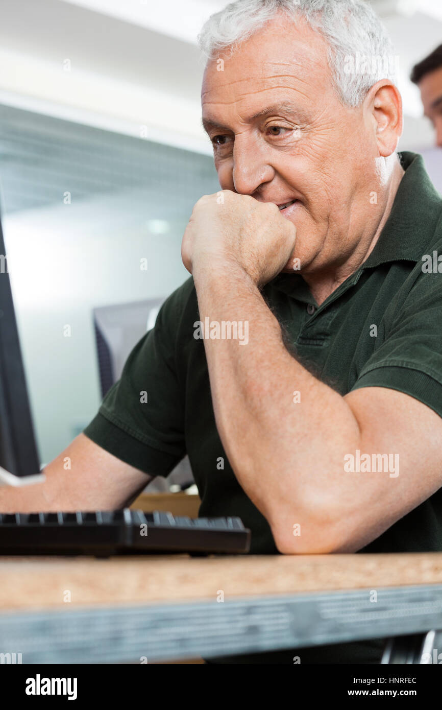 Senior uomo l uso dei computer in aula Foto Stock