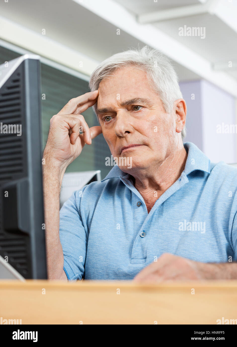 Preoccupato anziano studente guardare il computer in classe Foto Stock