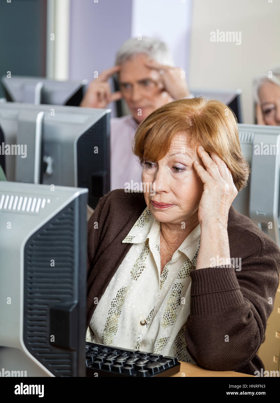 Tensionata senior donna guardare il computer in aula Foto Stock