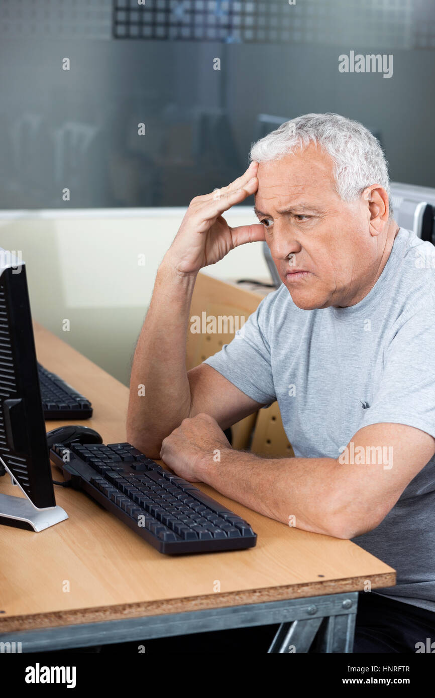Preoccupato anziano studente guardare il computer Foto Stock