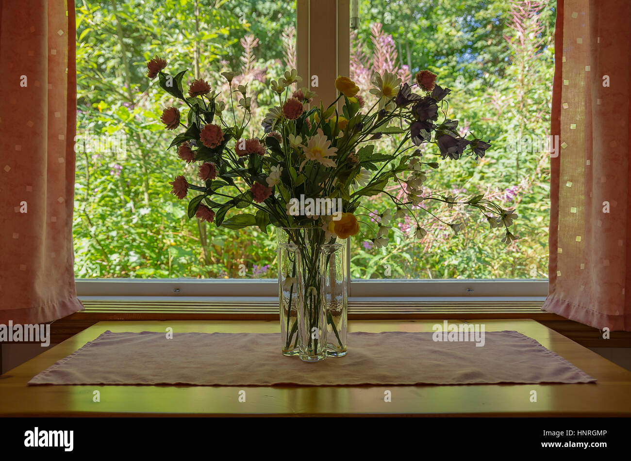 Interior shot di una vita ancora i fiori di plastica nella finestra . Foto Stock