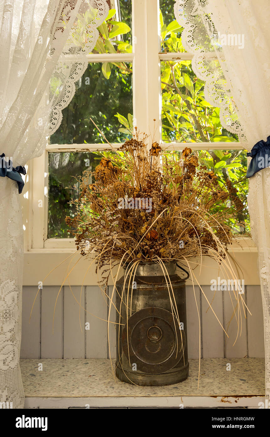 Nostalgica vita ancora di fiori secchi in un latte può. Foto Stock