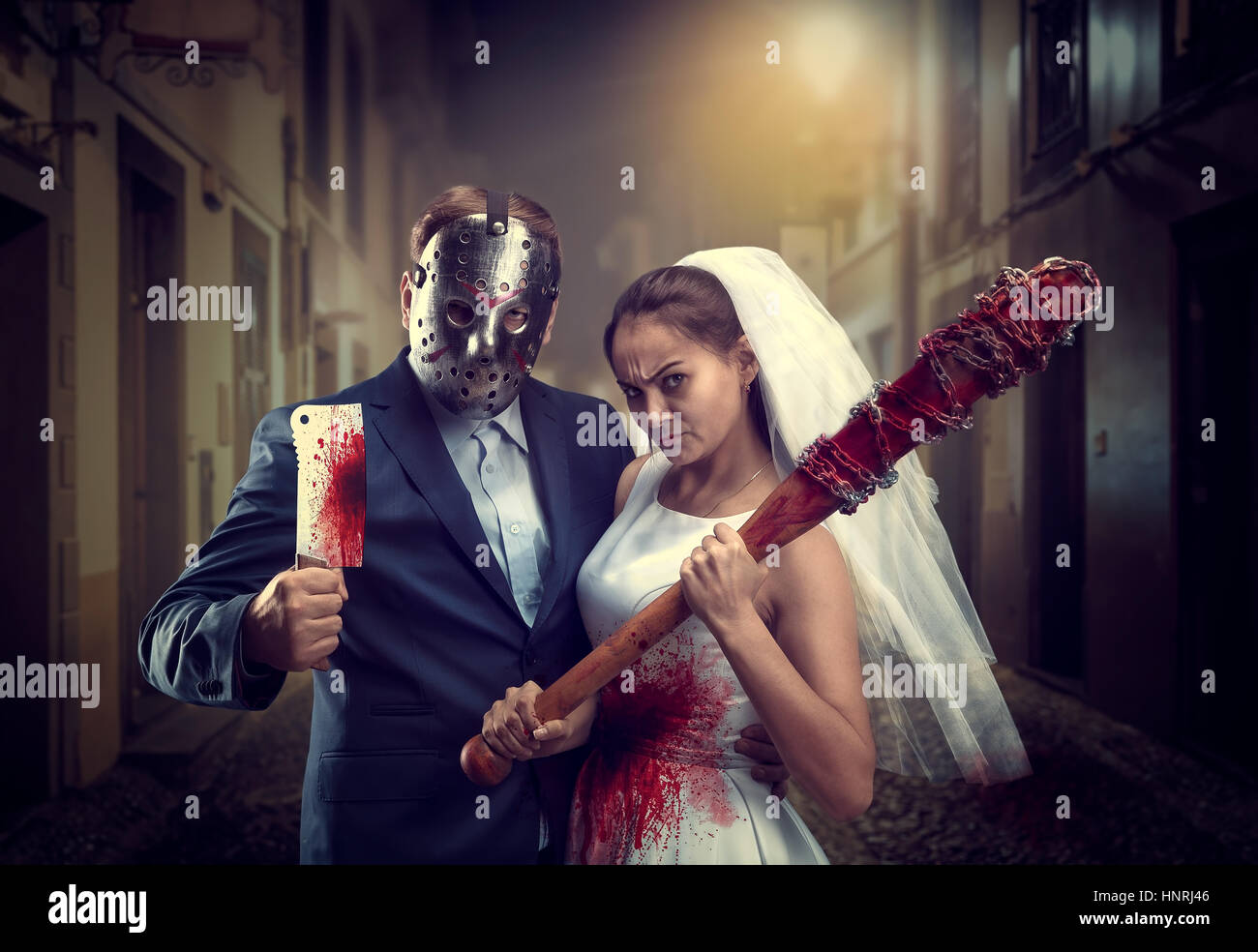Maniac giovane con sanguinosa bat e carne cleaver nella città di notte. Lo  sposo nella maschera di hockey Foto stock - Alamy