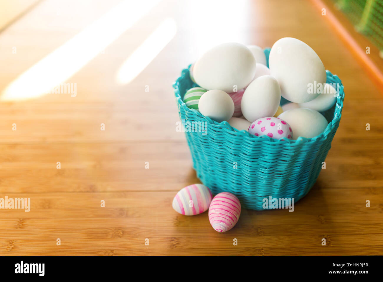 Cesto di pasqua con uova su un pavimento di legno Foto Stock