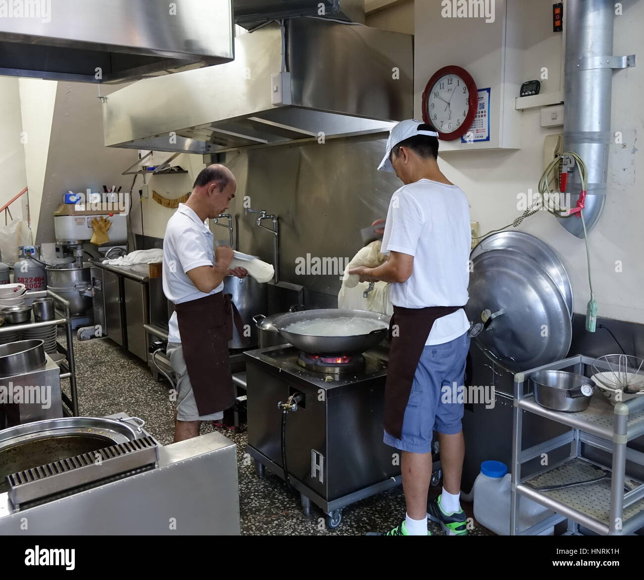 KAOHSIUNG, Taiwan -- Luglio 24, 2016: due cuochi prepara a Coltello tagliare tagliatelle, un piatto tradizionale da nord-ovest della Cina. Foto Stock