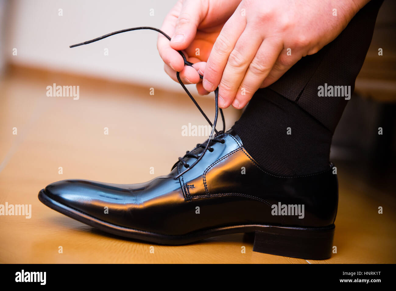 Lo sposo mettendo le sue nozze scarpe. Mani closeup. Foto Stock