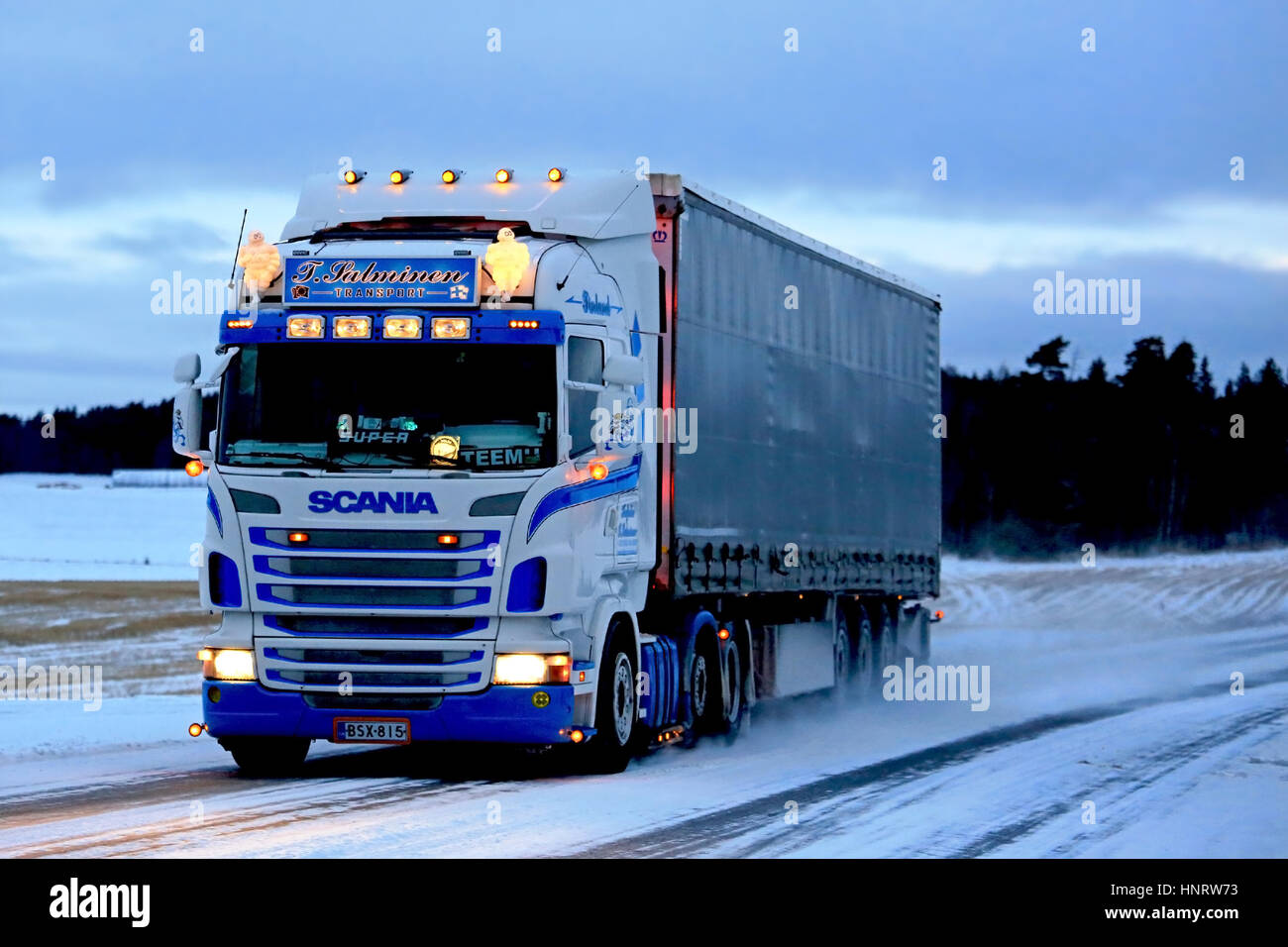SALO, Finlandia - 7 gennaio 2017: Personalizzato Super Scania di T. Salminen trasporto semi rimorchio si muove lungo la strada innevata a dusktime nel sud di Finla Foto Stock