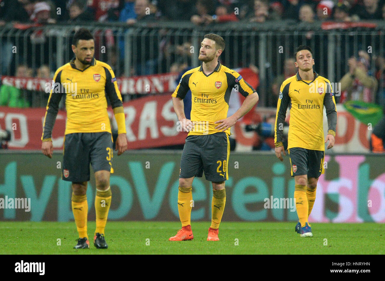 Monaco di Baviera, Germania. 15 Feb, 2017. Dell'Arsenal Francis Coquelin (l-r), Shkodran Mustafa e Mesut Ozil reagire dopo il loro lato ammette il quarto obiettivo della partita in prima gamba della Champions League round di 16 il tirante tra il Bayern Monaco e Arsenal FC in stadio Allianz Arena di Monaco di Baviera, Germania, il 15 febbraio 2017. Foto: Sven Hoppe/dpa/Alamy Live News Foto Stock