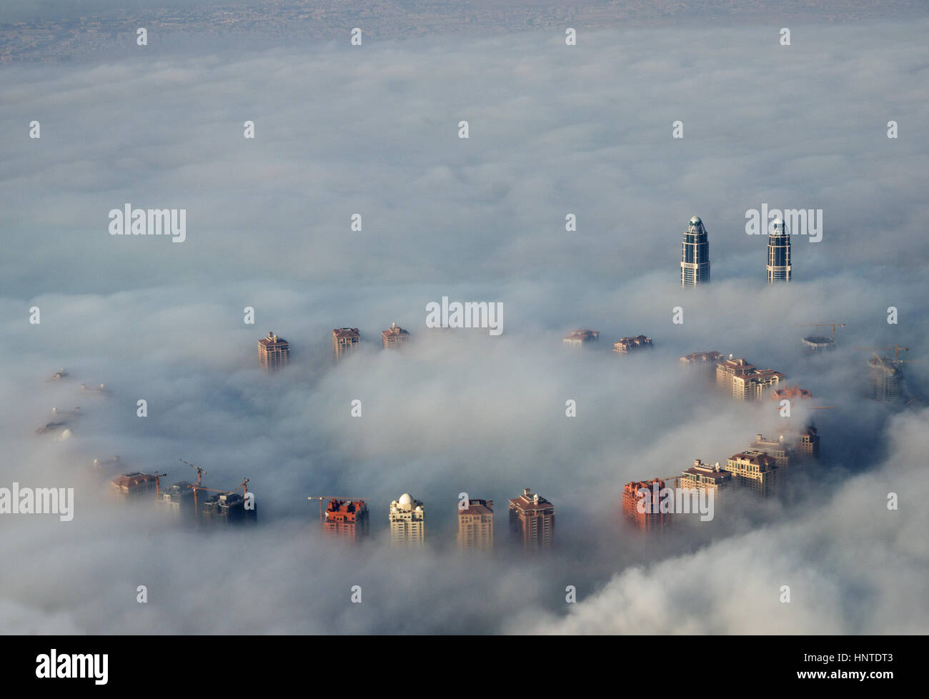 Edifici alti salire al di sopra di terra della nebbia come visto da sopra a Doha, in Qatar Foto Stock