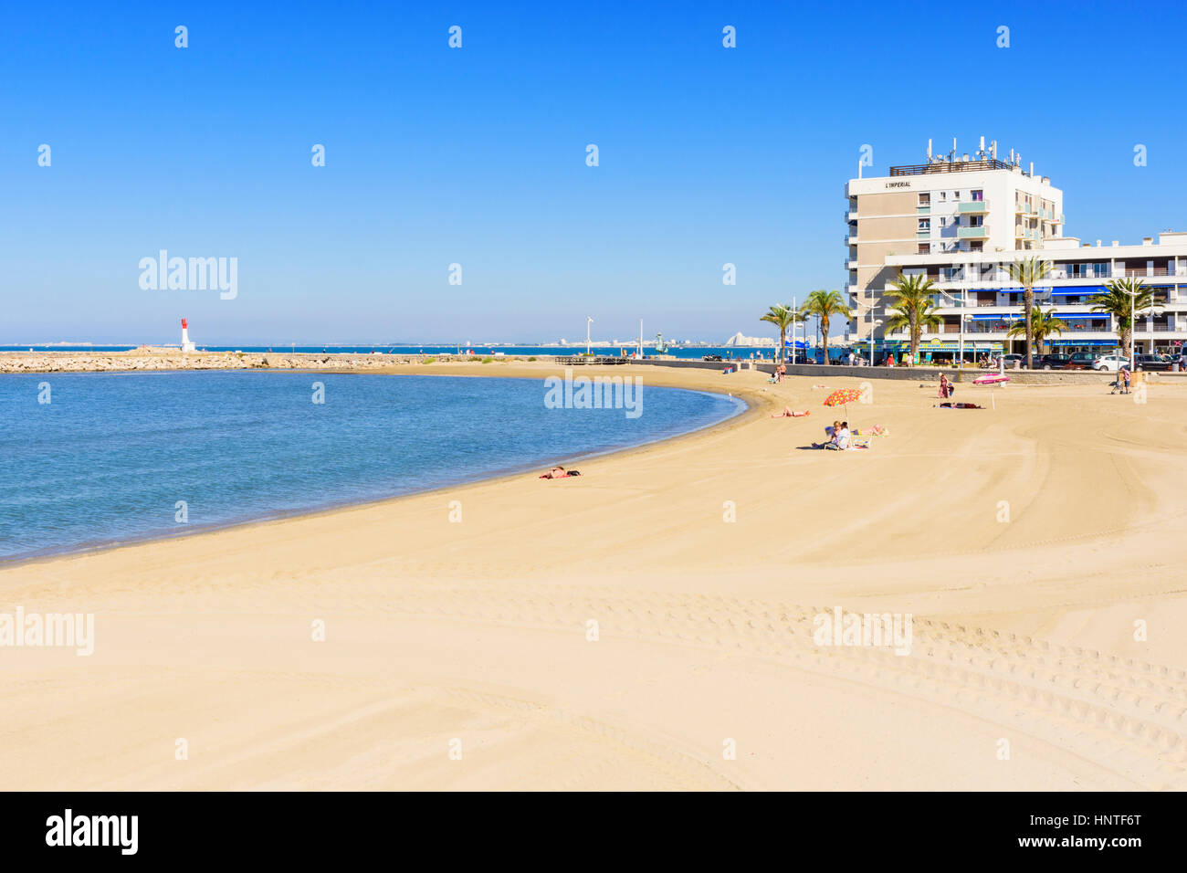 L'arco di soffice sabbia verso il molo, Plage Rive Gauche, Le Grau-du-Roi, Gard, Francia Foto Stock