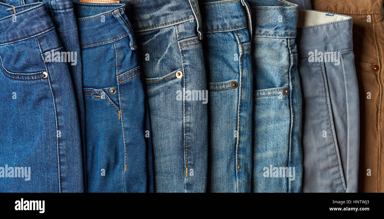 Selezione di diverso colore blu jeans giacciono sulla pila Foto Stock