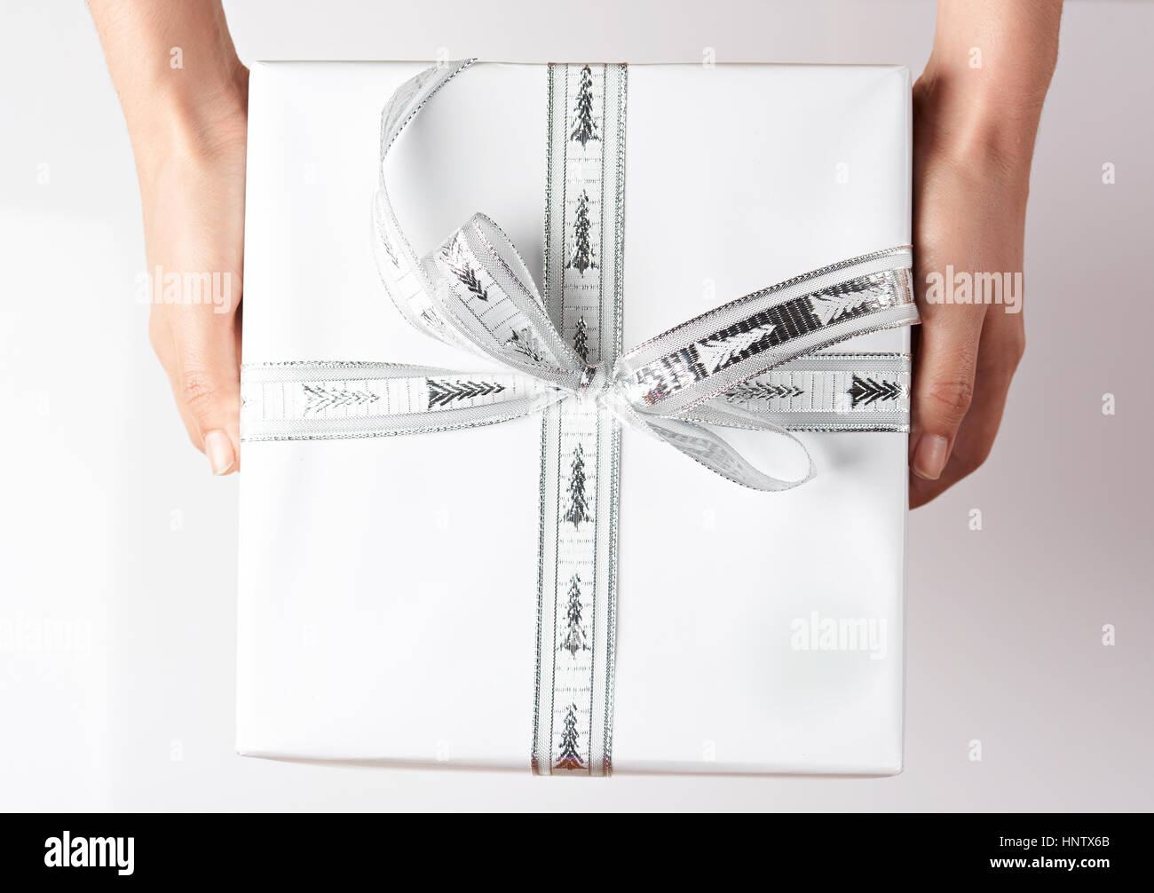 Scatola regalo bianca tenendo le mani vicino la vista dall'alto Foto Stock