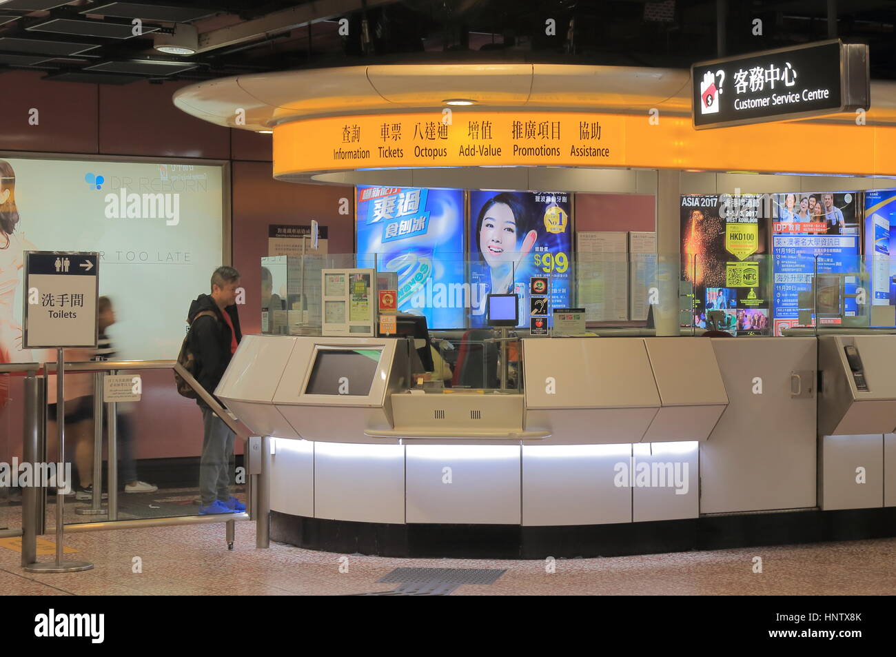 Visitare la gente di Hong Kong alla metropolitana MTR informazioni contatore in Hong Kong. Foto Stock