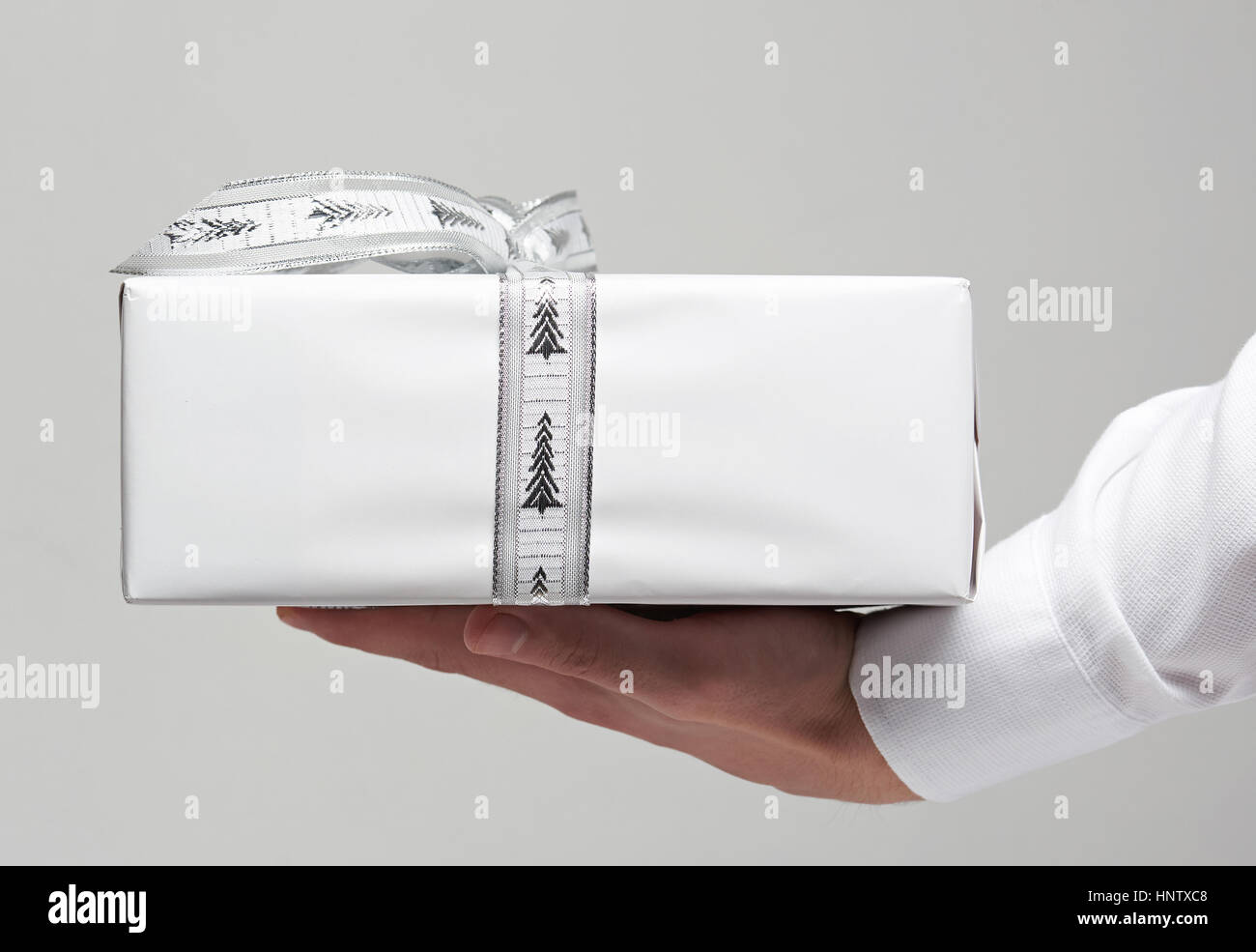 Scatola regalo bianca sulla palma umana in office camicia bianca closeup Foto Stock