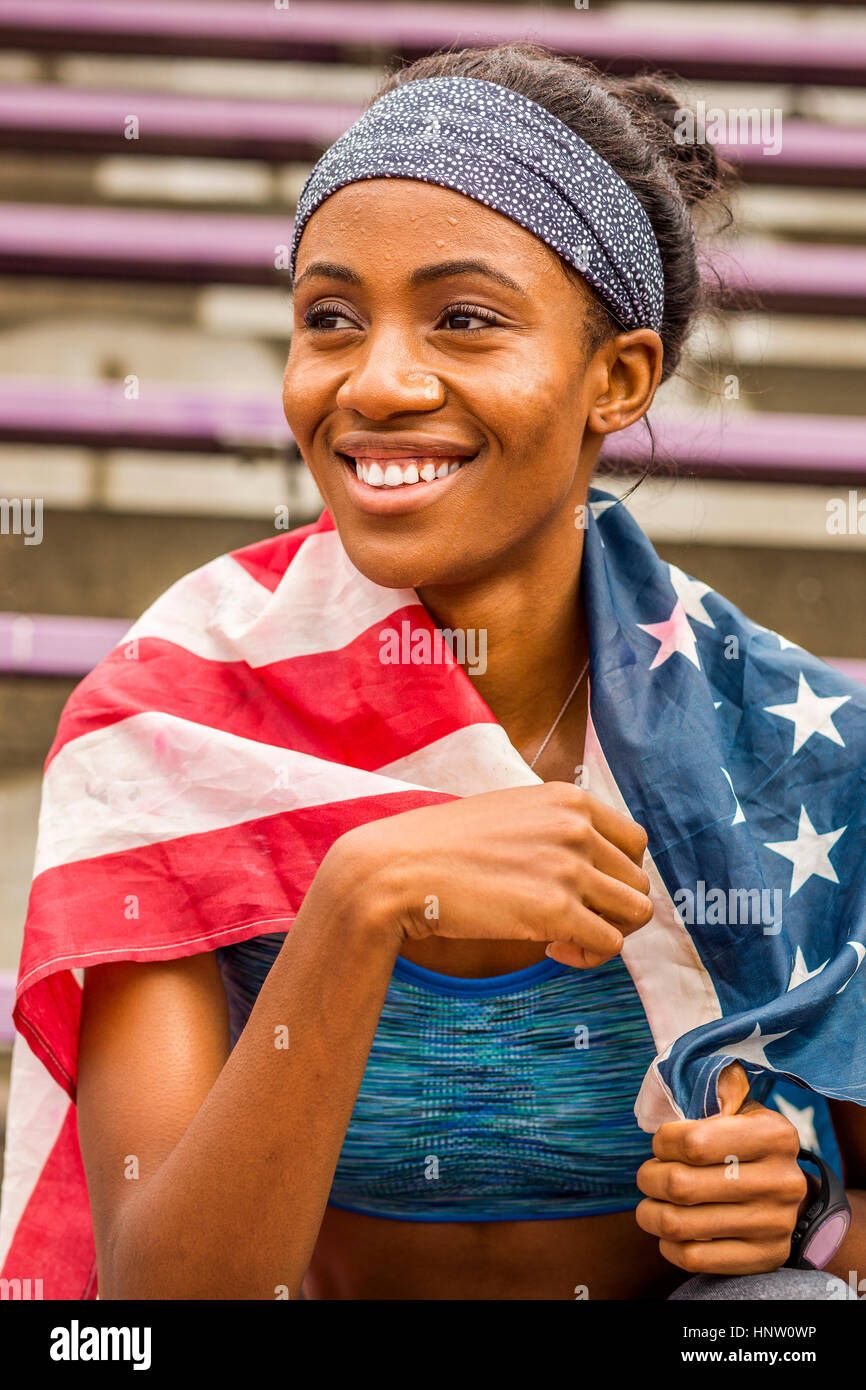 Sorridente atleta nero avvolto nella Bandiera americana Foto Stock
