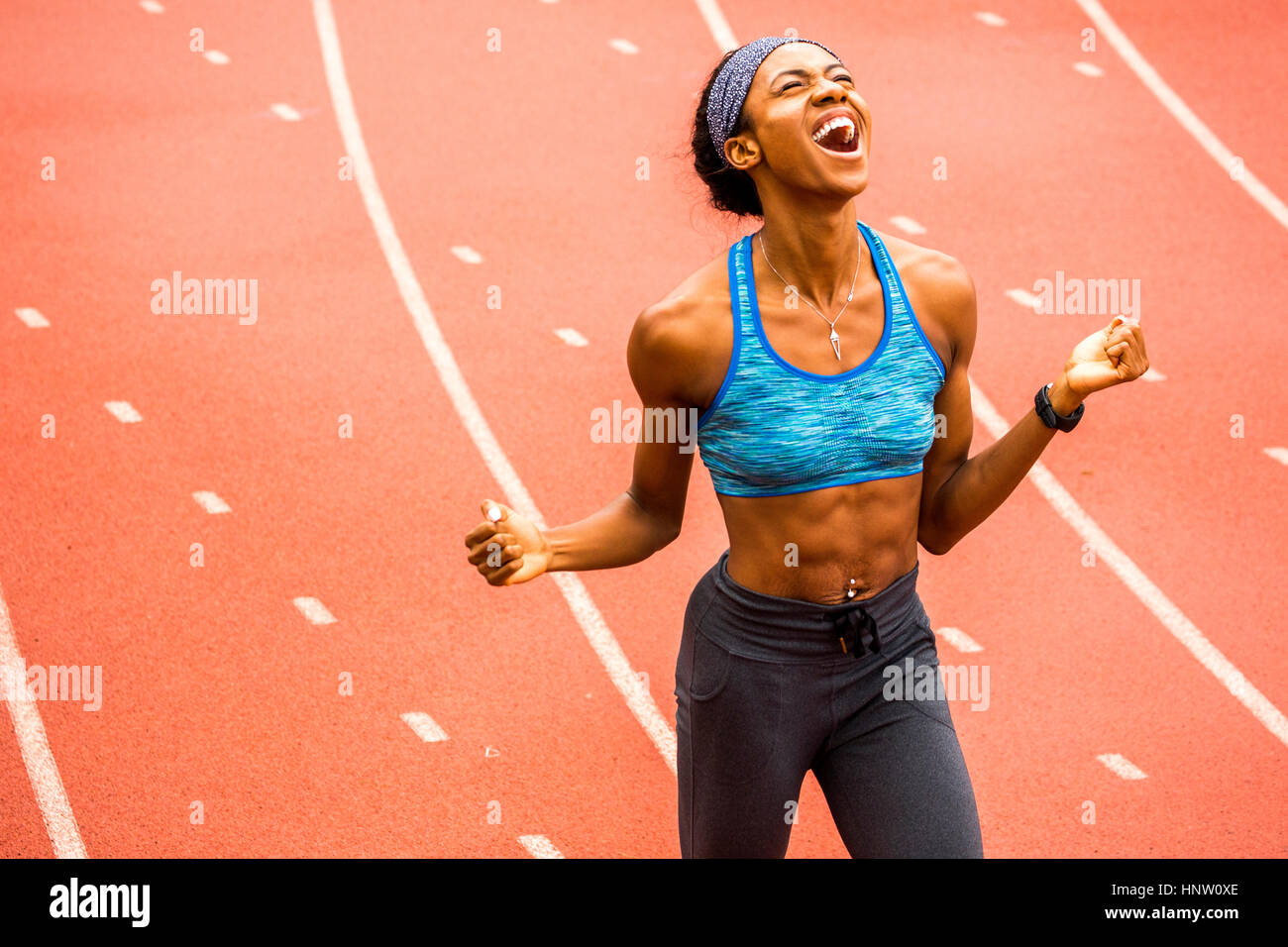 Felice atleta nero celebrando in via Foto Stock