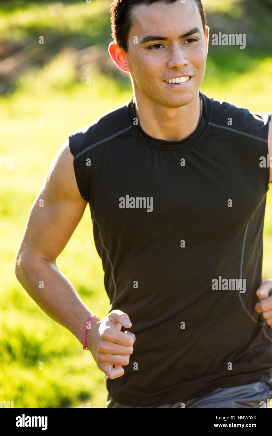 Sorridente razza mista uomo che corre Foto Stock