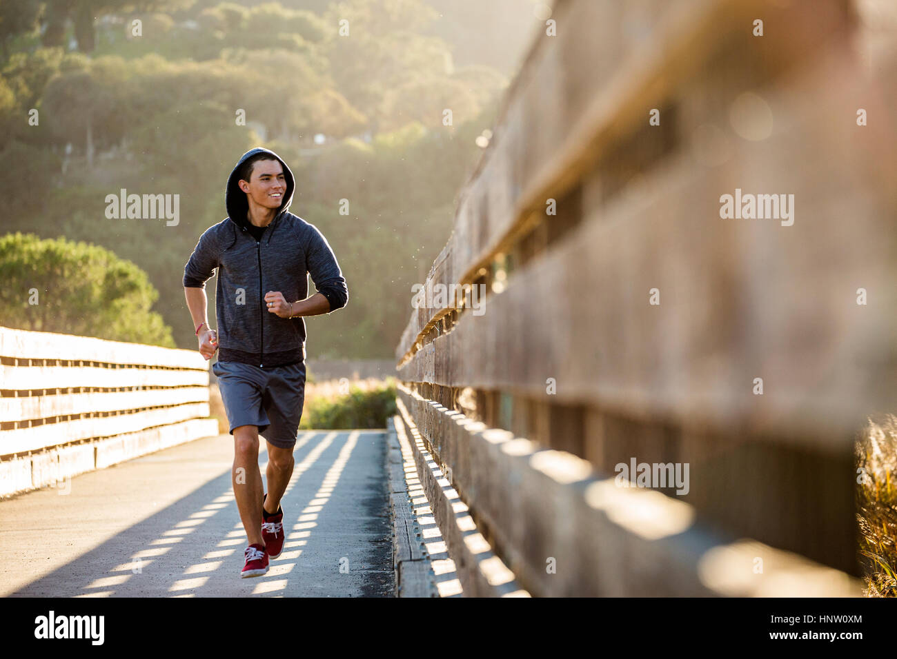 Sorridente razza mista uomo in esecuzione su passerella Foto Stock