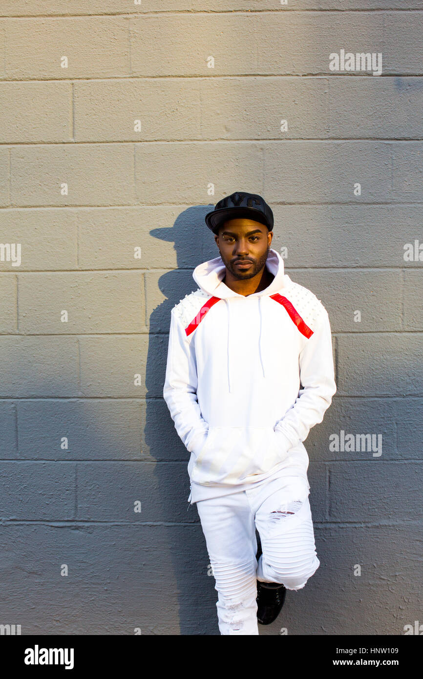 Grave uomo nero appoggiato sulla parete grigia Foto Stock