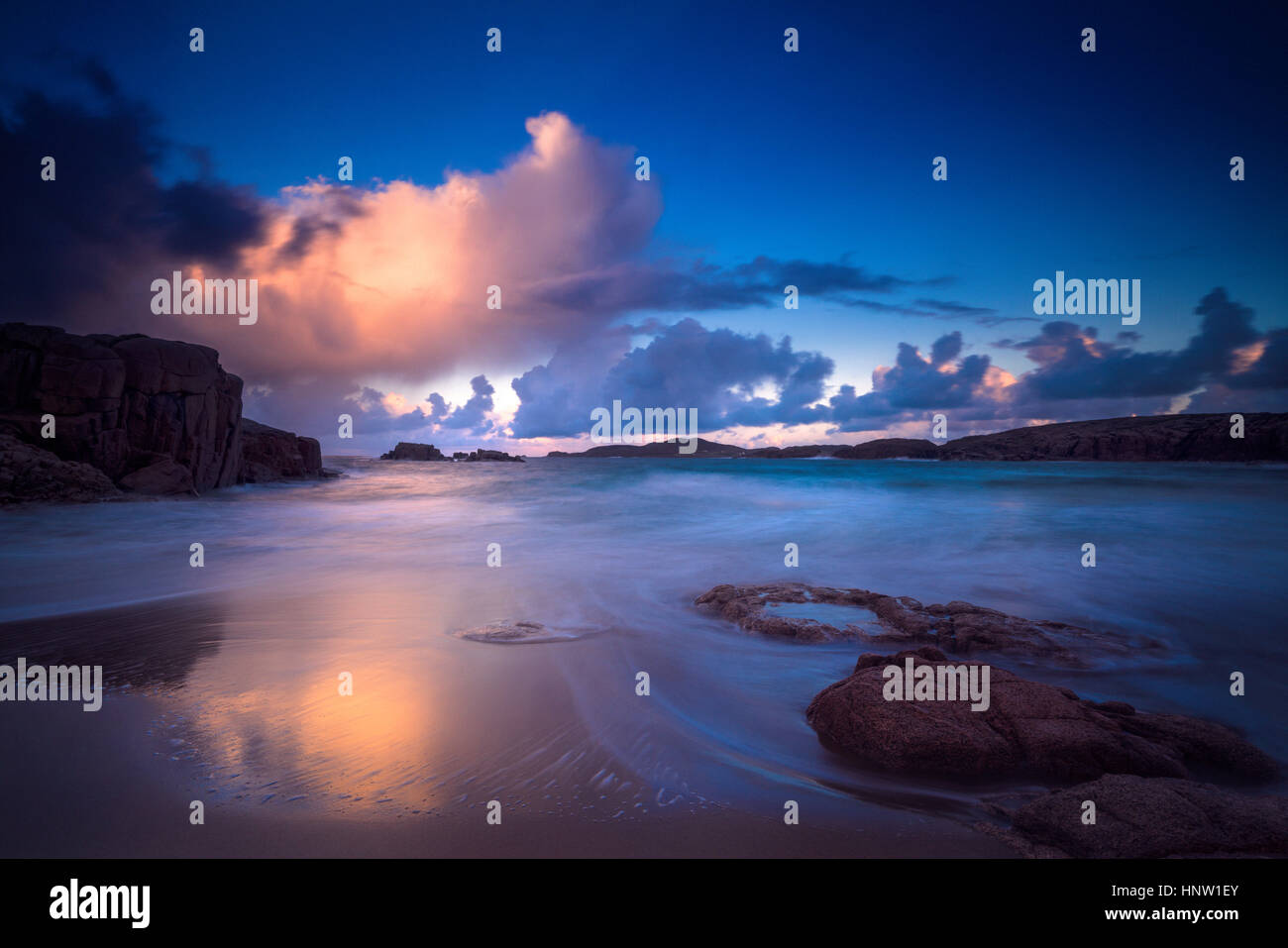 Calma onde sulla spiaggia al tramonto Foto Stock