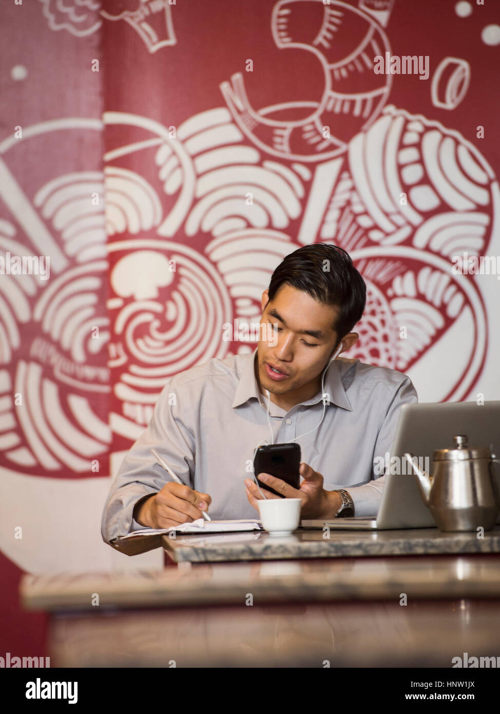 Imprenditore cinese parlando al cellulare nel ristorante Foto Stock