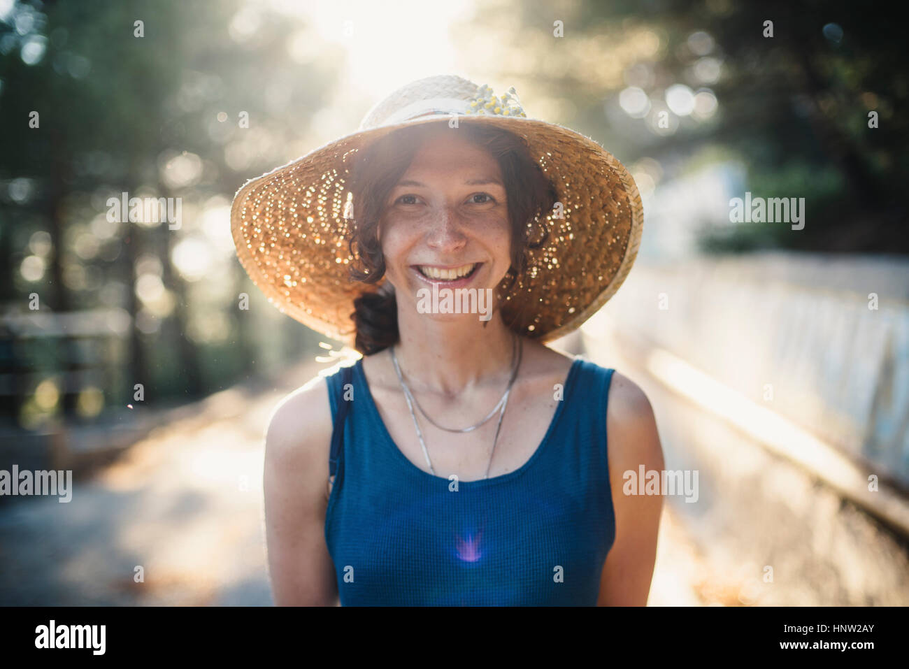 Sorridente donna caucasica indossando cappello per il sole Foto Stock