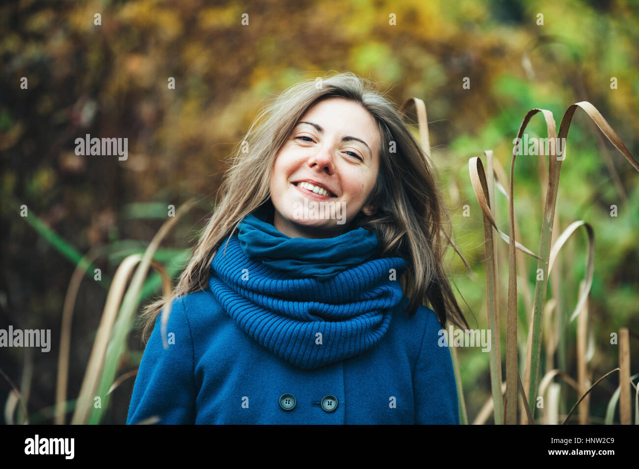 Sorridente donna caucasica indossando blue coat e sciarpa Foto Stock