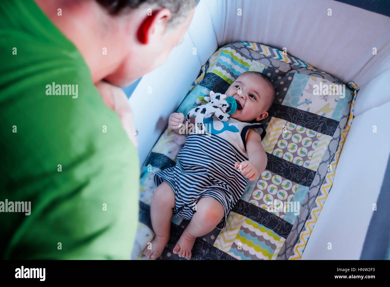Padre guardando figlio bambino nel presepe Foto Stock