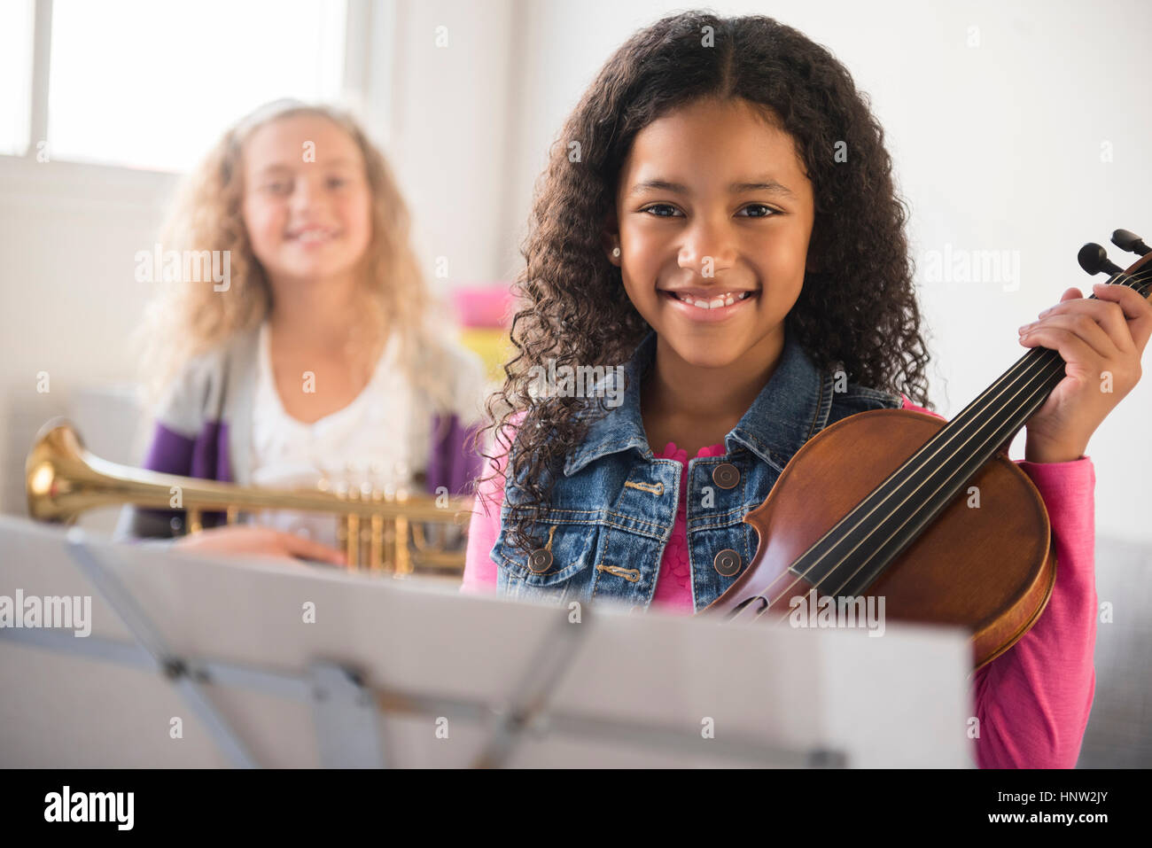 Ragazze sorridenti in posa con violino e tromba Foto Stock