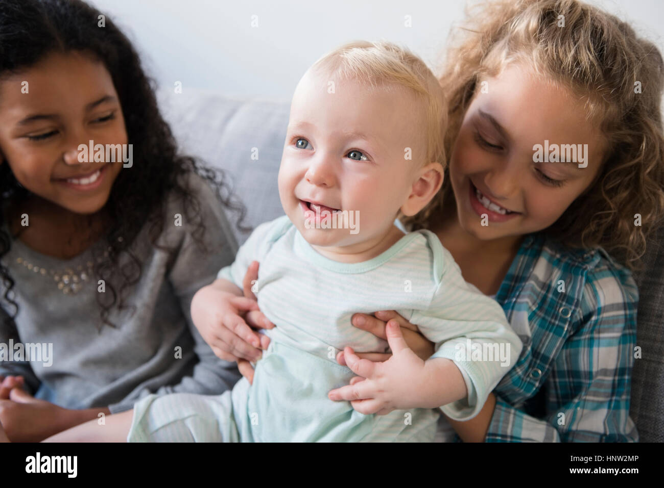 Amico guardando sorridente ragazza con baby fratello Foto Stock