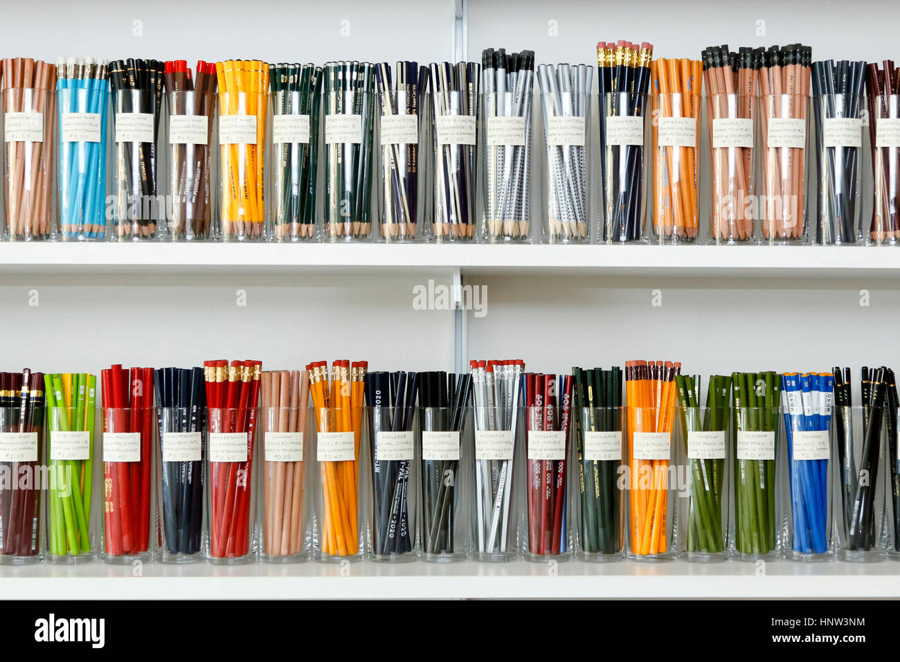 Varietà di matite in tazze sugli scaffali del negozio Foto Stock