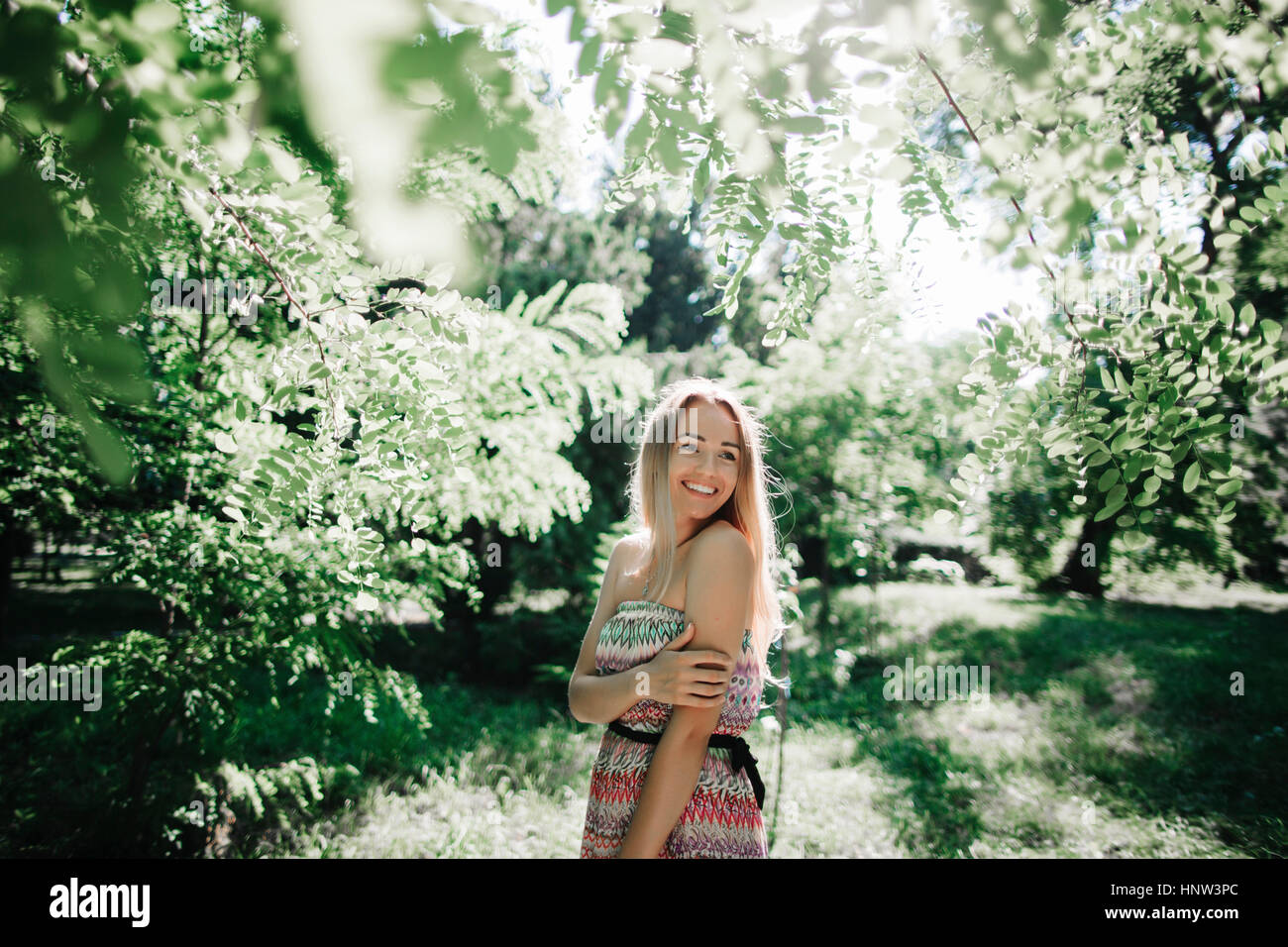 Caucasian donna in piedi vicino a verdi alberi Foto Stock
