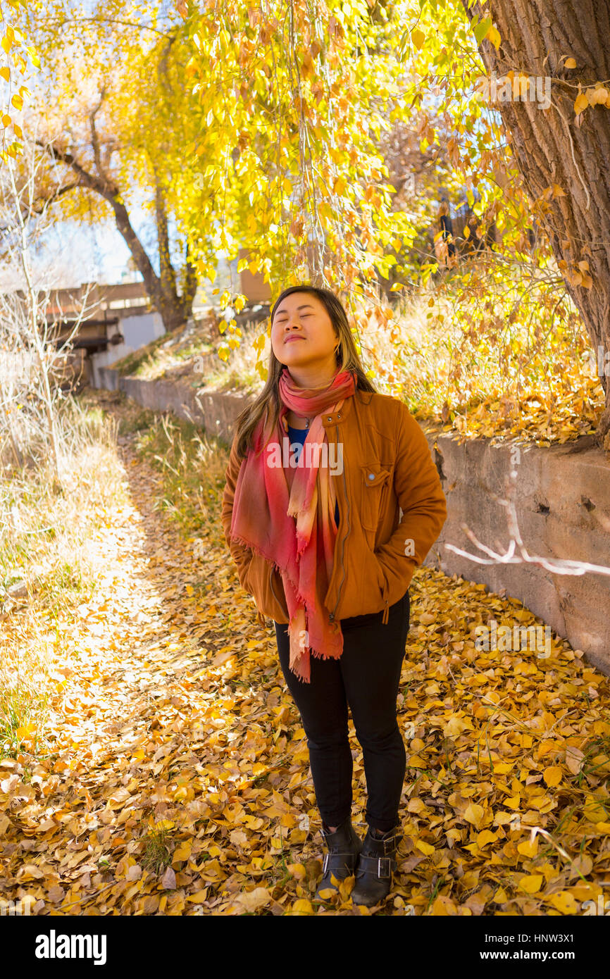 Sorridente donna asiatica odore di aria fresca in autunno Foto Stock